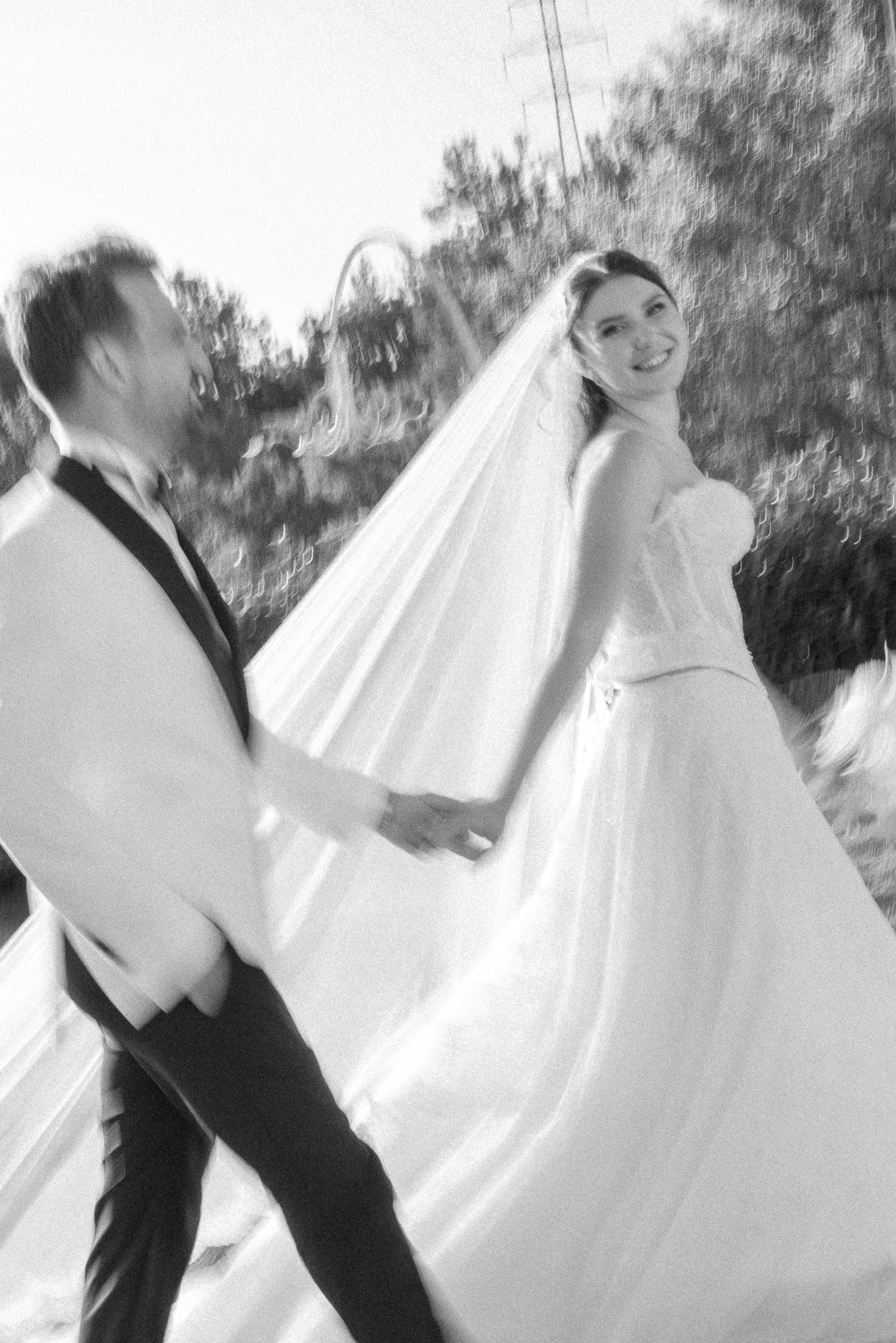 Hareketli siyah-beyaz karede gülümseyerek arkasına bakan gelin ve damat